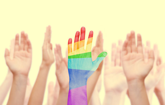 Man's hands painted as the rainbow flag