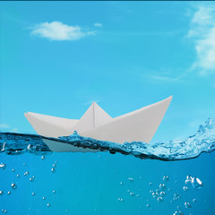Obraz premium paper boat floating among the waves in the ocean