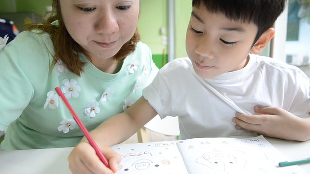 Asian Mom is painting her son to do homework of the school