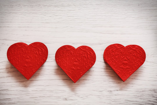 valentines day background with three hearts on wooden background