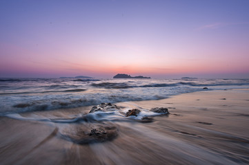 Obraz premium Landscape of sea with dramatic wave and rock in sunset.