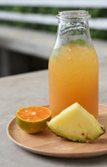 different bottles of juice with fruits on wooden table