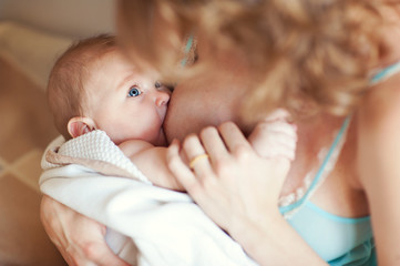 Young european mother breast feeding her newborn baby