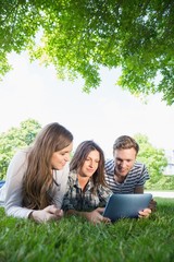 Fototapeta premium Happy students using tablet pc outside