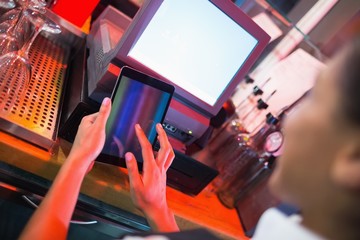 Pretty barmaid using touchscreen till