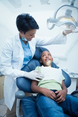 Female dentist examining boys teeth