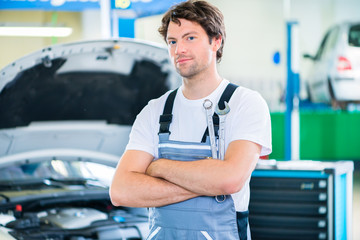 KFZ-Mechaniker arbeitet in Autowerkstatt