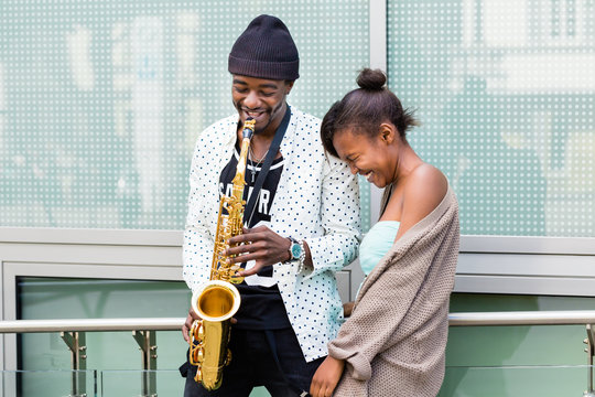 Afrikanisches Paar spielt Saxophon auf Stra&szlig;e