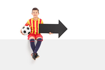 Junior athlete holding an arrow and a football