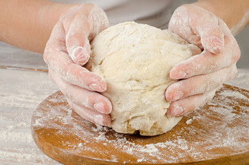 Woman Hands preparing dough  on  wooden table