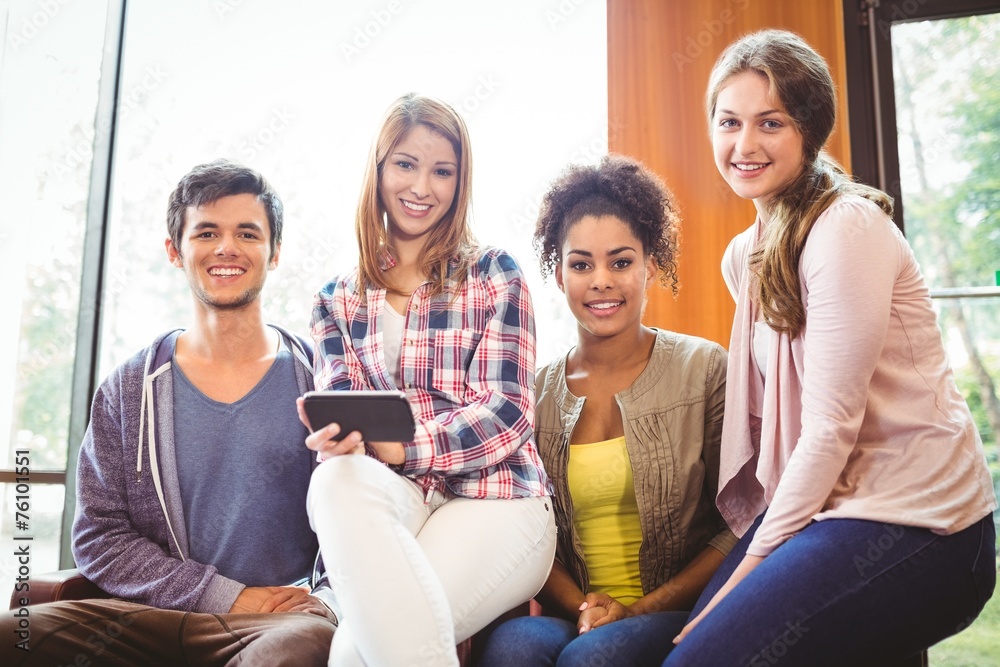 Poster happy students sitting on a sofa using mobile phone