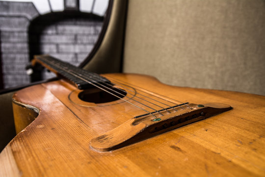 Close-up of acoustic guitar lying on the sofa