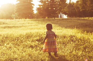 Little cute girl having fun at sunset. Toned