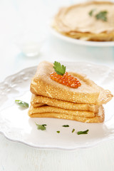 Pancakes with caviar, sour cream and parsley