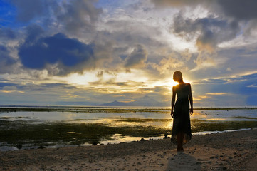 Woman stay at the Sunset over Bali as seen from Gili, Indonesia - obrazy, fototapety, plakaty
