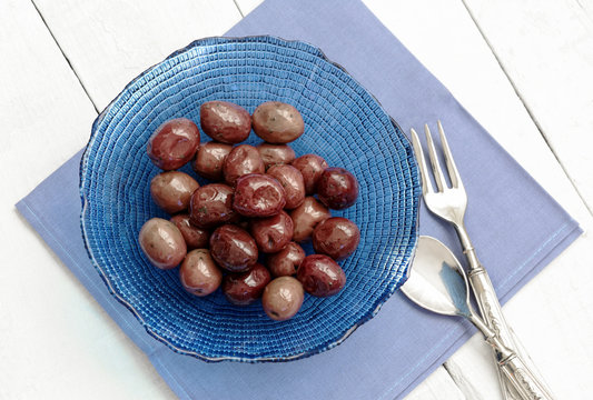 olives inside blue glass bowl with vintage fork and spoon