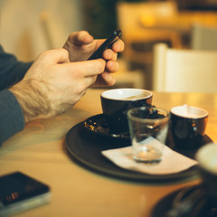 Fototapeta na wymiar man in coffee shop using smart phone