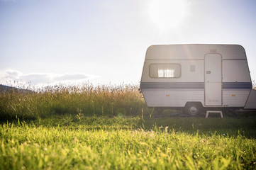 Caravan trailer on rural sunny setting - obrazy, fototapety, plakaty