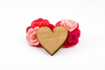 Obraz na płótnie Canvas Wooden heart with pink and red wool flowers on white background