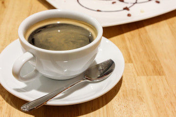 A cup of black coffee on the wood table