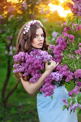 Outdoor portrait of a cute girl against beautiful lilac on a nic