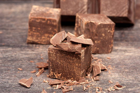 pieces dark chocolate on a wooden background