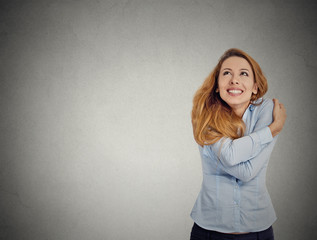confident woman holding hugging herself looking up