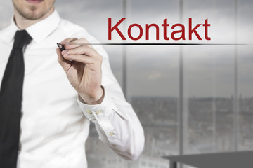 Geschäftsmann in Büro schreibt Kontakt in die Luft