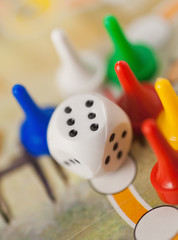 white dice cube near multicolored counter on game field