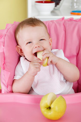 Happy baby eating fruit