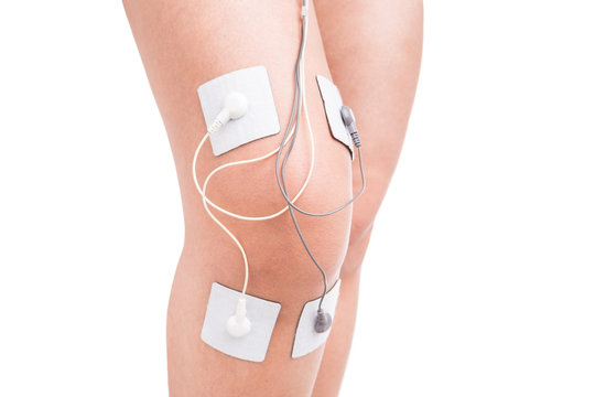 Electrostimulator massager on her knee. Injury athlete.