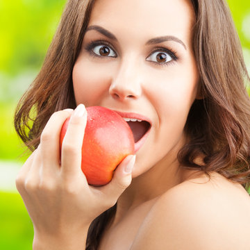 Woman eating red apple, outdoor