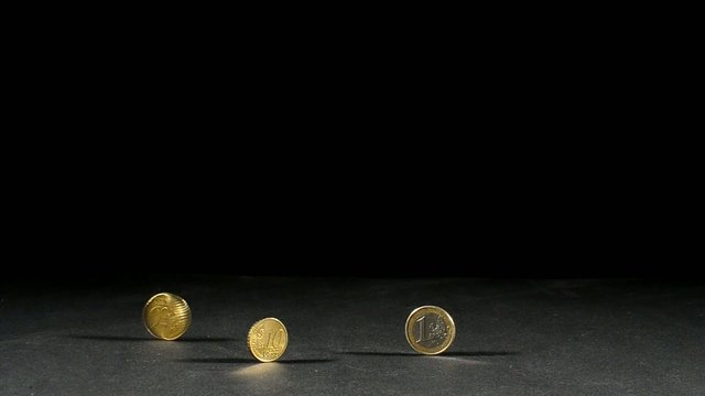 drei euro muenzen und eine in bewegung mit schwarzen hintergrund