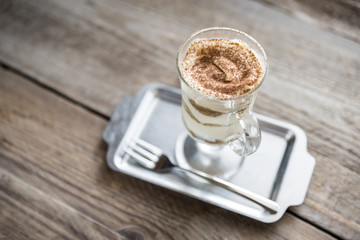 Tiramisu in the glass on the wooden background