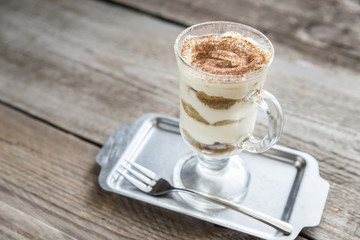 Tiramisu in the glass on the wooden background