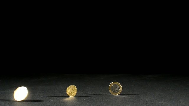 drei euro muenzen und eine in bewegung mit schwarzen hintergrund