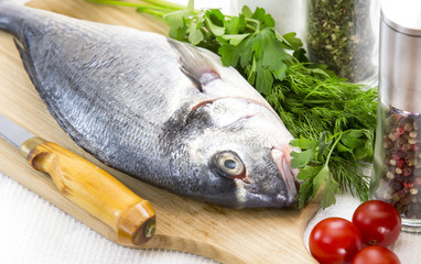 raw fish on a cutting board and knife