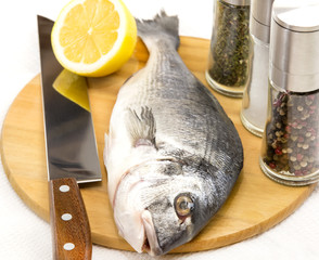 raw fish on a cutting board and knife