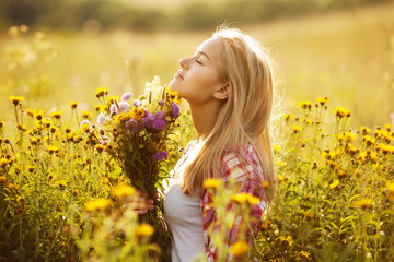 Beautiful girl among the wildflowers in summer