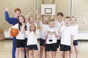 Fototapeta premium School Basketball Tean And Coach Celebrating Victory With Trophy