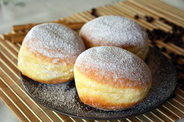 Donuts with powdered sugar on the brown plate