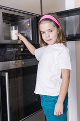 Child preparing a glass of milk