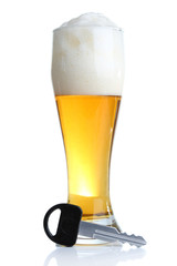 Composition with car key and glass of beer, isolated on white