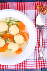 Soup with meatballs and noodles in bowl on wooden background