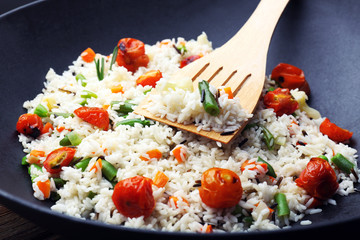 Tasty rice preparing in wok, close-up
