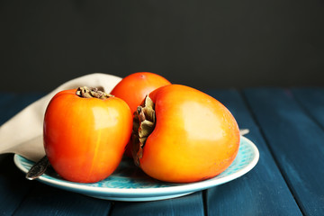 Ripe sweet persimmons, on wooden table