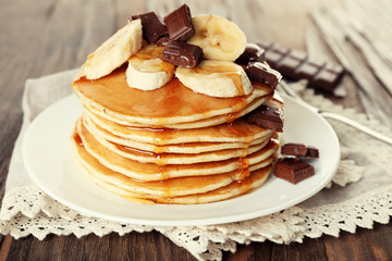 Stack of delicious pancakes with chocolate, honey and slices of