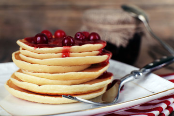 Stack of delicious pancakes with cranberries and jam