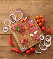 Slices of salami with spices and vegetables