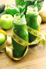 Green fresh healthy juice in glass bottles with fruits and © Africa Studio